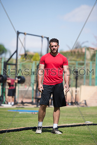 Portrait of a young middle eastern Athletic-built man in the external field of fitness which is preparing for exercise