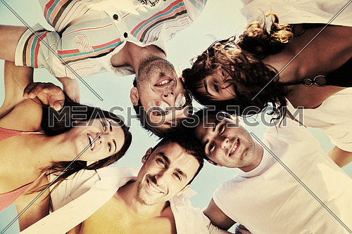 happy young friends group have fun and celebrate while jumping and running on the beach at the sunset