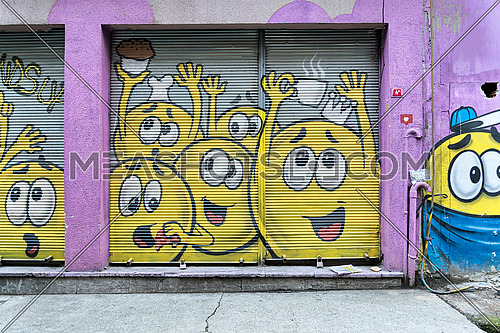 Istanbul, Turkey - April 18, 2017:  Closed shop exterior with metal door covered with colorful graffiti at Karakoy district, Istanbul, Turkey