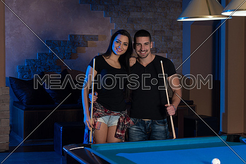Portrait Of A Young Couple Playing Billiards