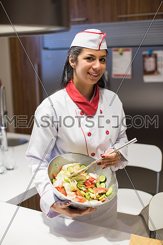 young female middle east chef preparing a salad in the kitchen