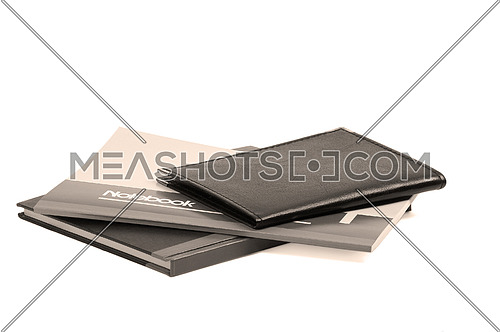 assorted notebooks flat piled on white background,sepia filter