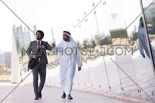 arabian  business people  walking in front of modern corporate building