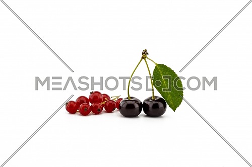 Two ripe cherries with a green leaf and a bunch of red currants isolated on a white background