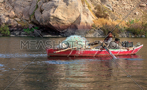 two fishermen in a rowing fishing boat in the river nile
