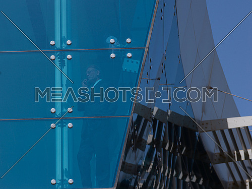 senior business man  on window  at modern office building outdoor shoot with blue sky in background