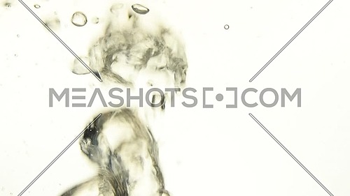 Extreme close up abstract background of air bubbles of hot boiling water emerging underwater over white background, low angle side view, slow motion