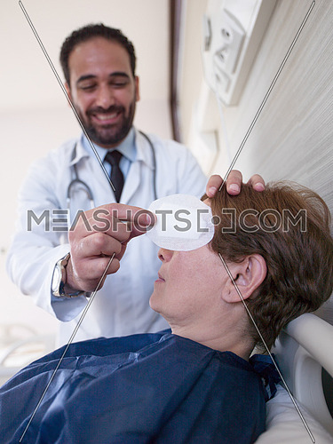 doctor and happy patient at eye clinic, doctor checking patients eye in optometry clinic