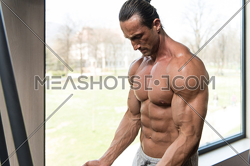 Muscular Mature Man Bodybuilder Doing Heavy Weight Exercise For Biceps