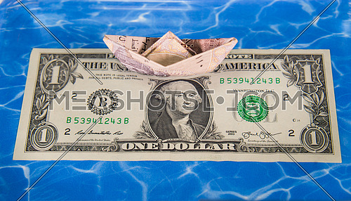 one Egyptian Pound folded like paper boat floating in water concept