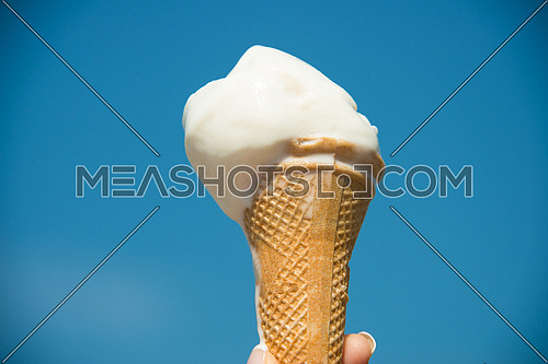 female hand holding ice cream biscuit cone