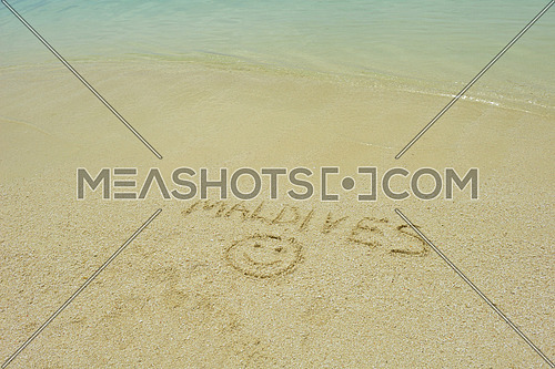 tropical beach nature landscape scene with white sand at summer with the word maldives written on the sand