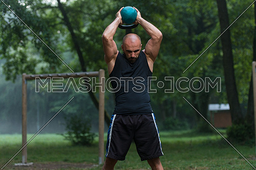 Fitness Man Lifting Kettlebell Workout Exercise Outdoors In Nature