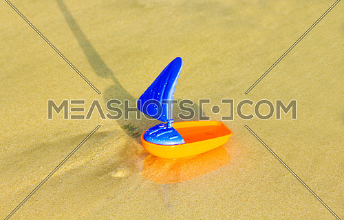a plastic toy boat on the beach