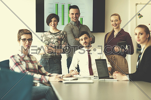 portrait of business people group at modern bright startup office meeting room, young  man with beard sitting  in middle as team leader