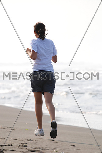 A young woman jogging by the sea