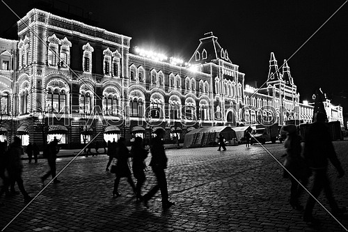 black and white image of the Red Square in moscow at Night with people walking in the streets