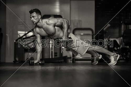 Young Man Athlete Doing Pushups With Dumbbells As Part Of Bodybuilding Training