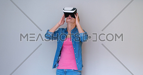 Happy girl getting experience using VR headset glasses of virtual reality, isolated on white background