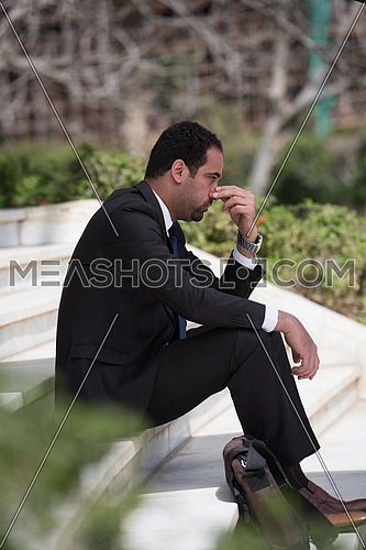 Frustrated business executive sitting on the stairs