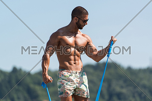 Sportsman Exercising With A Resistance Band Outdoors