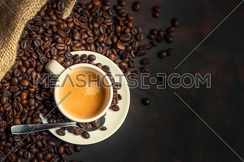 White cup of coffee and coffee bean on dark background. Copy space.view from above.