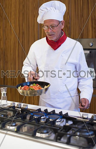 Senior middle east chef's fried meal in the kitchen with satisfaction