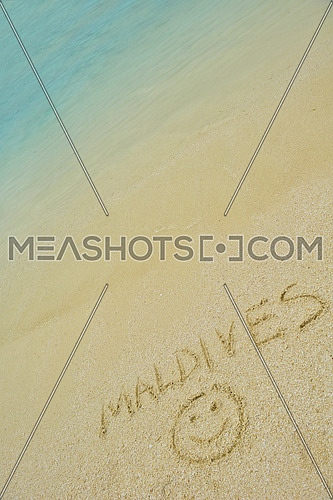 tropical beach nature landscape scene with white sand with the word maldives written on the sand at summer
