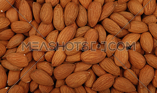 Whole raw brown almond nuts on retail market, close up, background, high angle, elevated top view