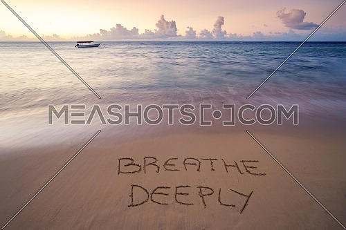 Handwritten Breathe deeply on sandy beach at sunset,relax and summer concept,Dominican republic beach.