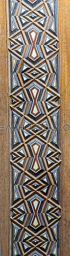 Closeup of wooden arabesque decorations tongue and groove assembled, inlaid with ivory and ebony, on door of minbar of historic public Mosque of Al Rifai, Old Cairo, Egypt
