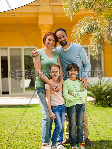 portrait of a happy middle eastern family in the yard of a beautiful sunny day