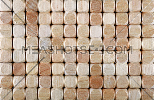 Close up background pattern of natural wooden dice shaped toy building blocks, elevated high angle view, directly above
