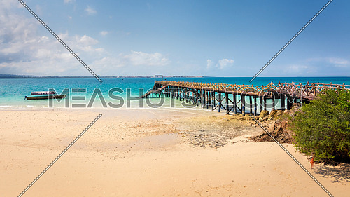 Pictured turquoise Indian Ocean and a beautiful wooden pier built on the shores of Prison Island in Zanzibar, Tanzania