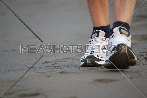 A close shot on sports shoes on the beach